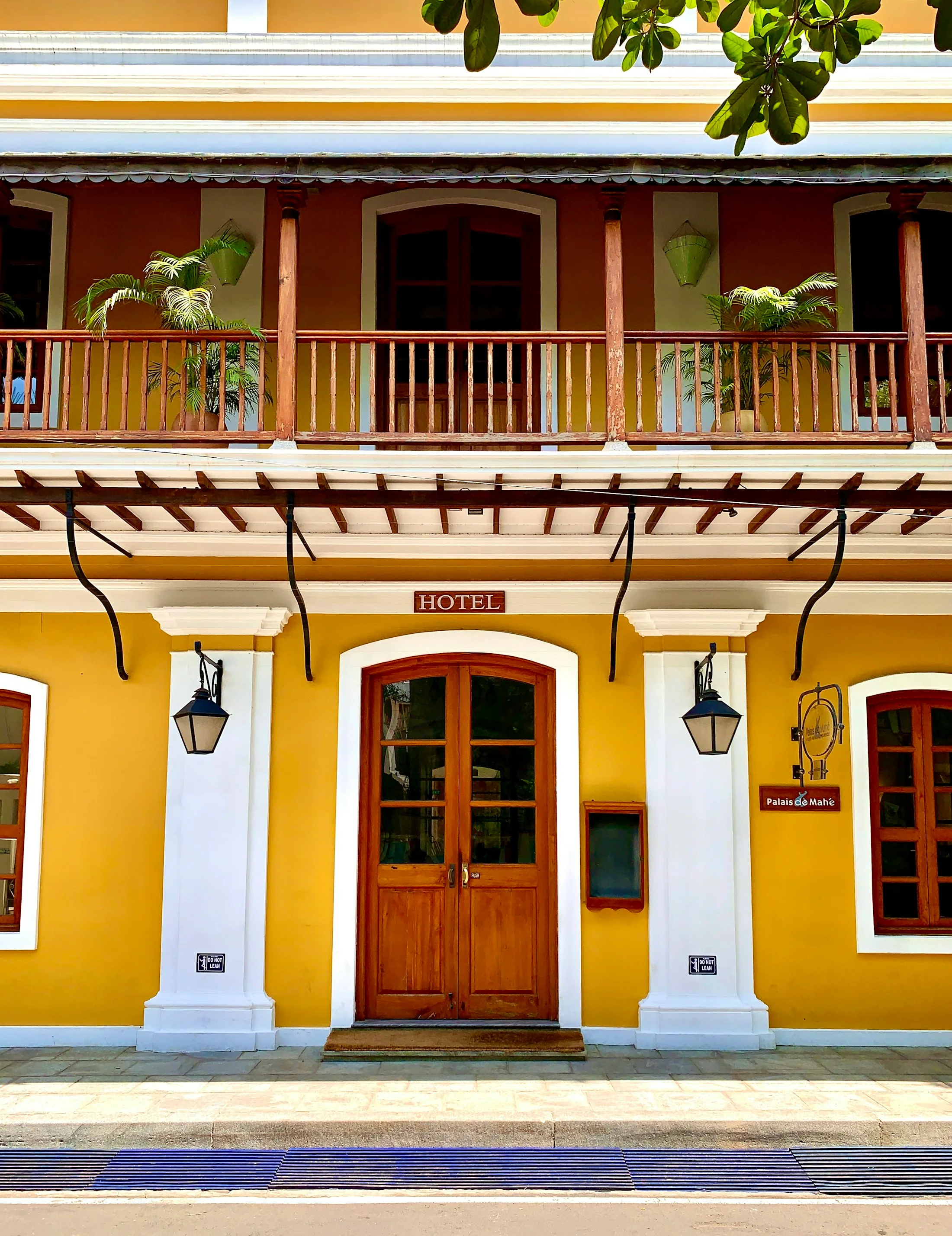 A mustard-yellow colonial house in Pondicherry’s French quarter with tall louvred shutters and a colonnaded veranda