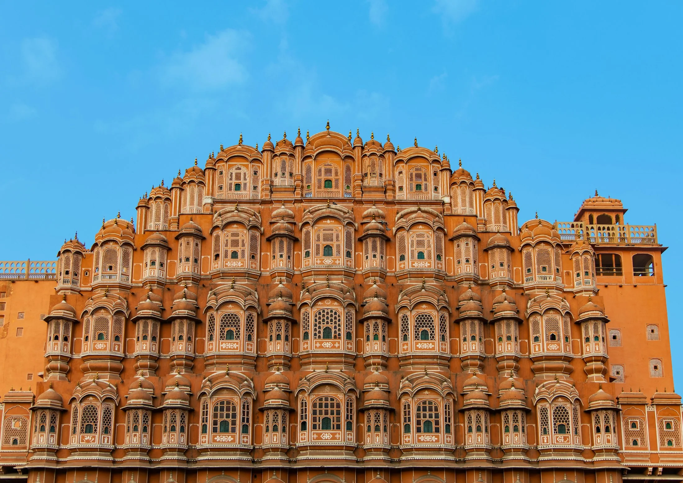 The pink sandstone façade of Hawa Mahal in Jaipur, tier upon tier of latticed windows