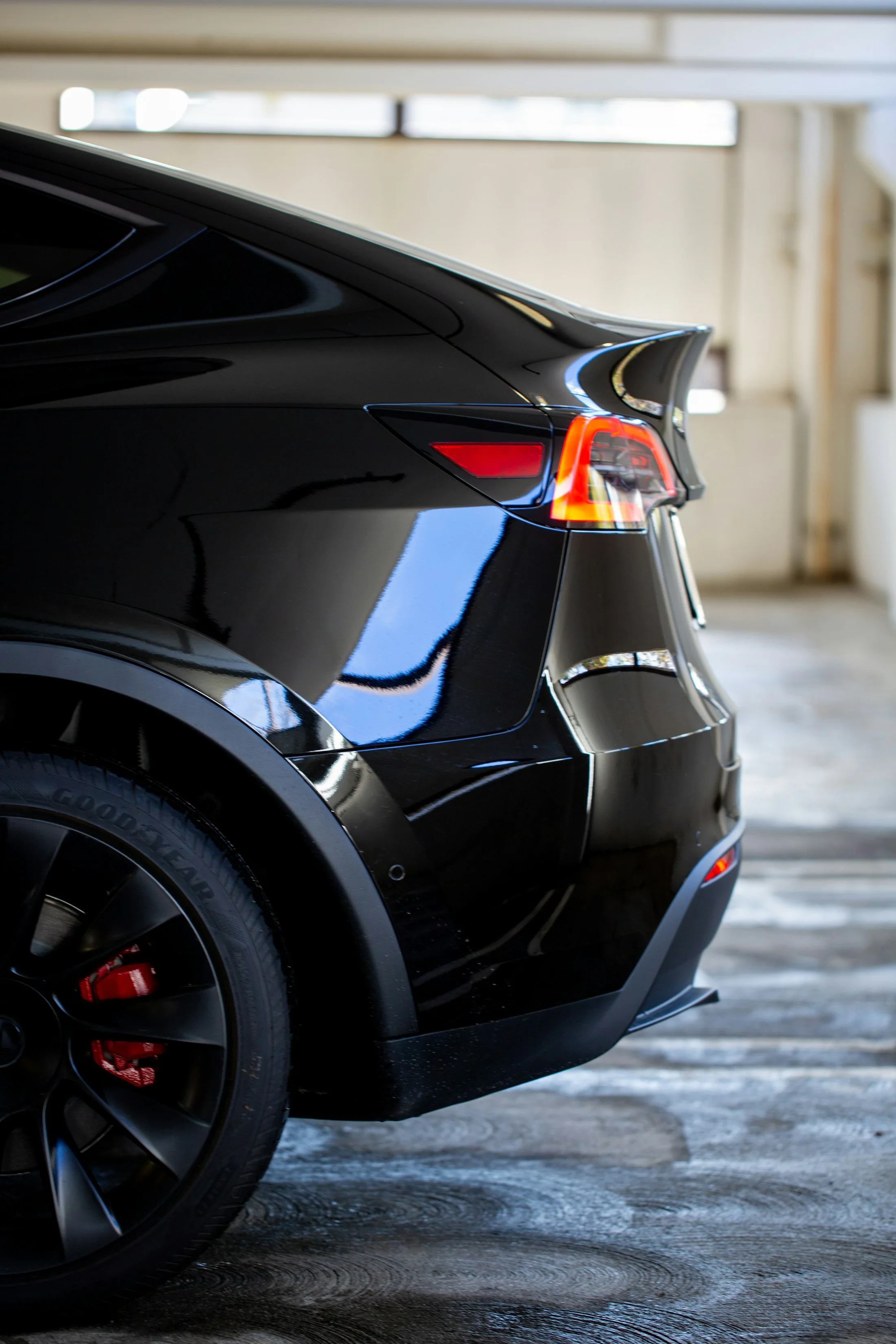 A polished black executive sedan photographed in profile on an open road