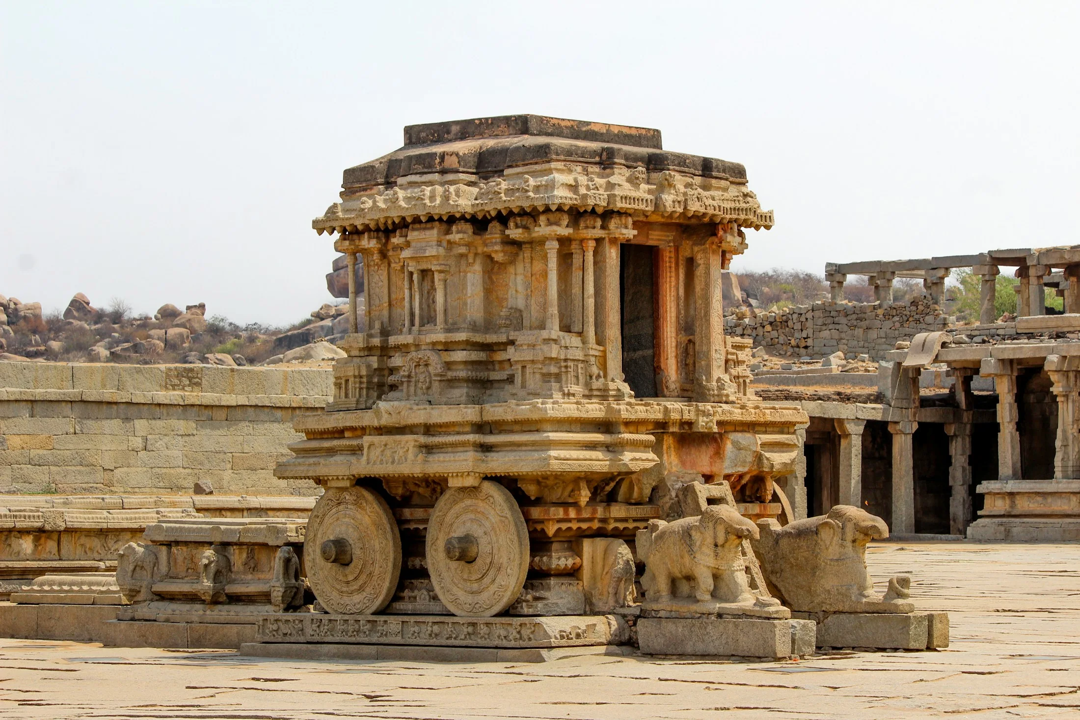 The carved stone chariot of the Vittala temple complex at Hampi standing in its courtyard of granite
