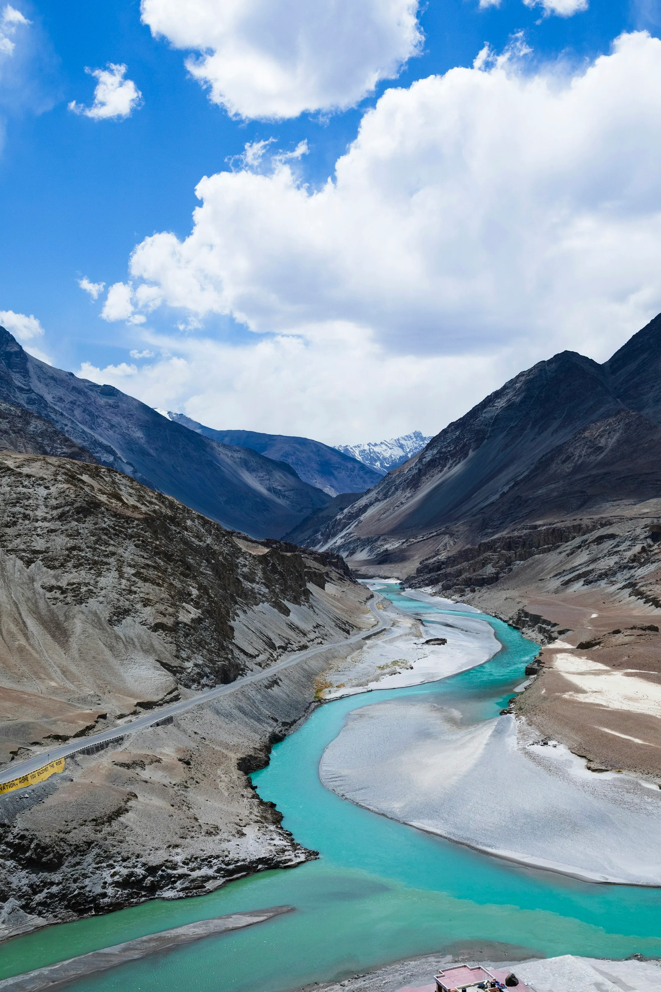 A brilliant turquoise high-altitude lake in Ladakh held between bare, snow-streaked mountains