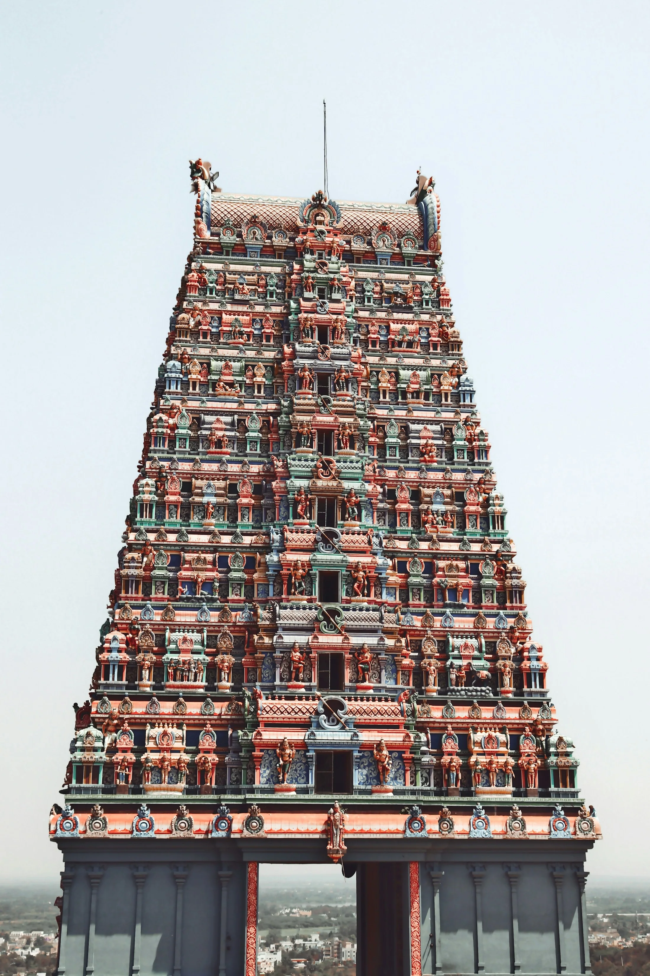 The towering gopuram of Meenakshi Amman Temple in Madurai, densely covered in painted sculptures of deities