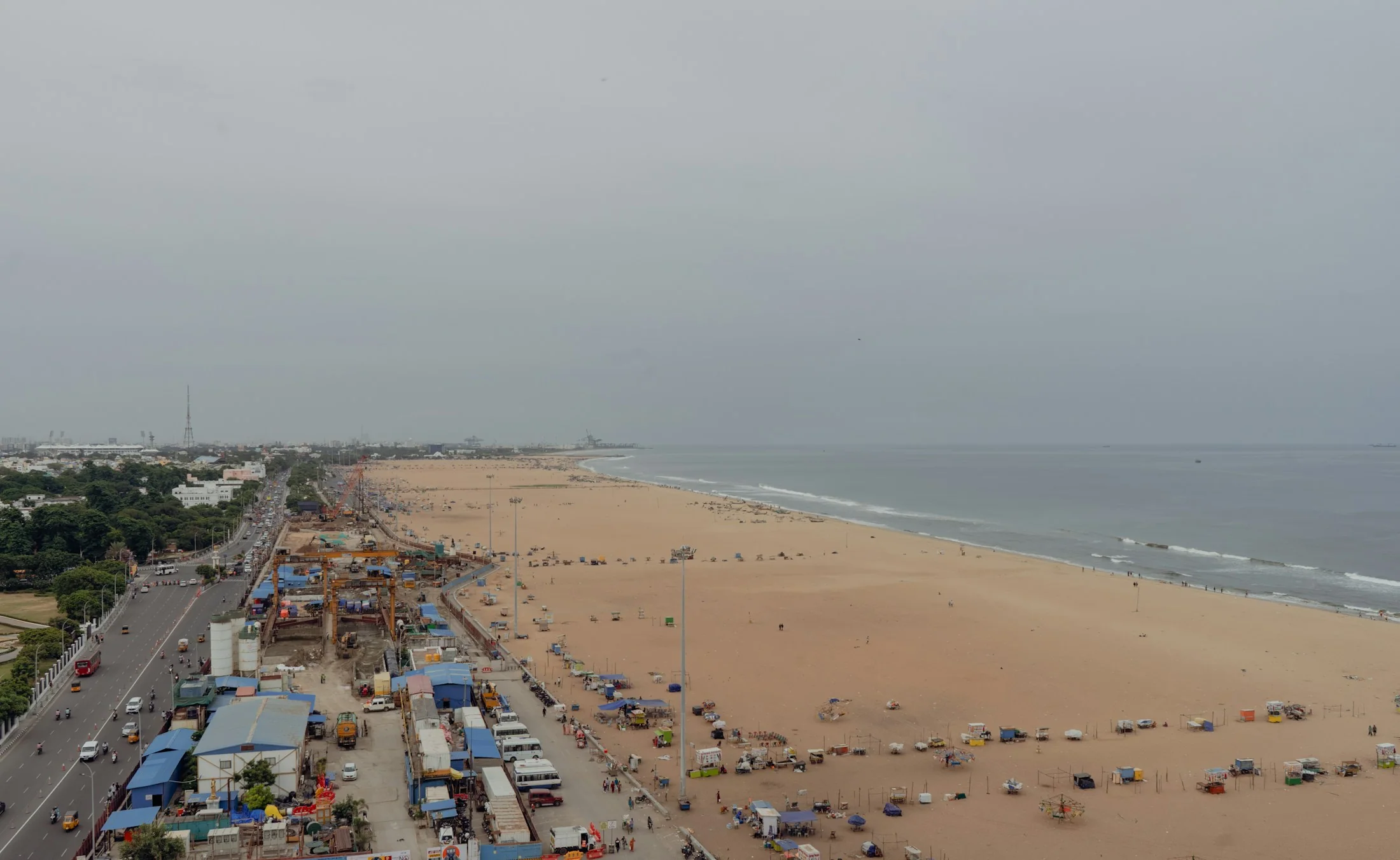 Marina Beach curving along the Chennai coastline, the city meeting a wide band of sand and the Bay of Bengal