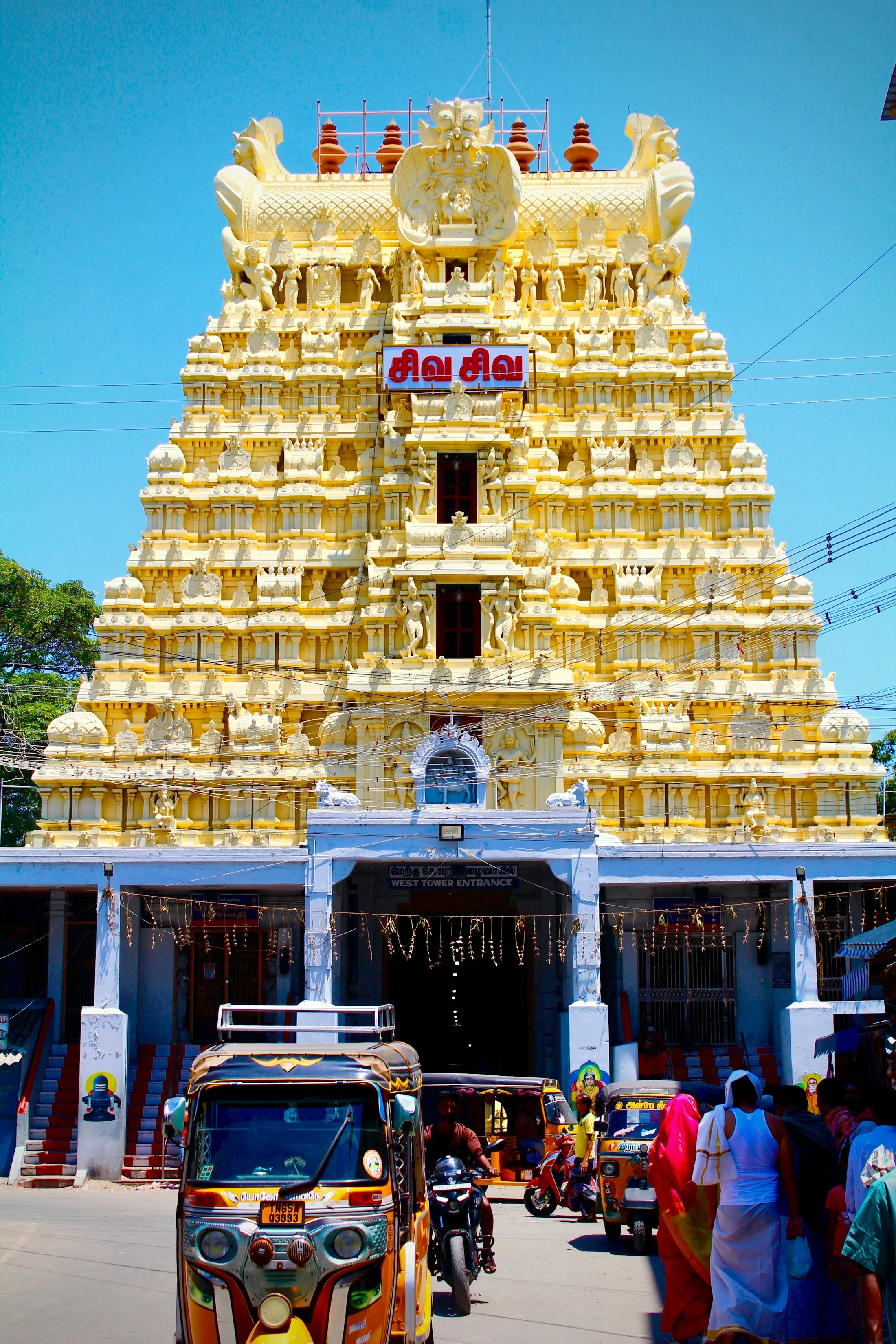 A tall temple tower at Rameswaram rising against an open sky, its tiers picked out in ochre and gold